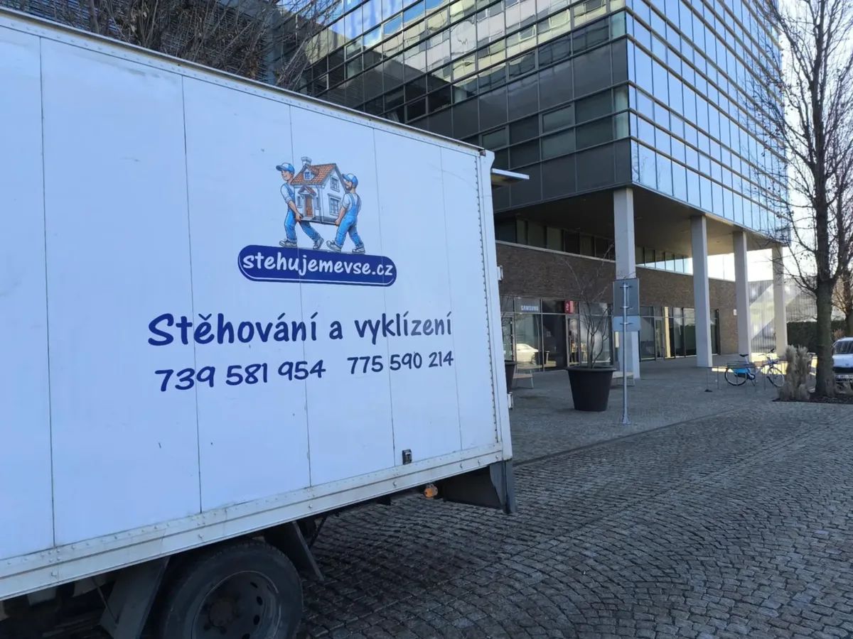 Stěhovací vůz firmy Stěhujeme Vše s logem před budovou v Brně